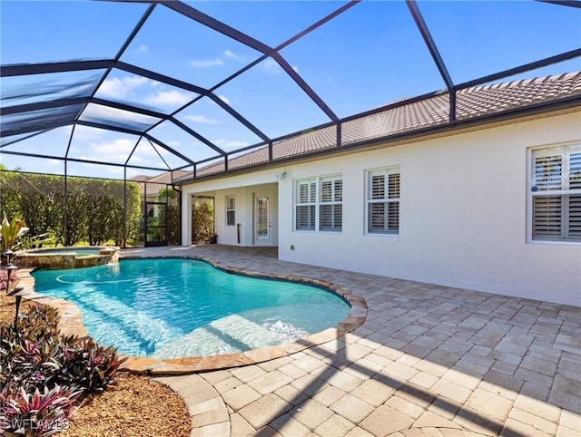 view of pool featuring an in ground hot tub, a patio area, and a lanai