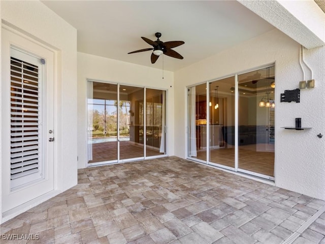 unfurnished sunroom featuring ceiling fan