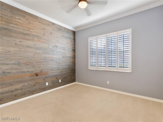 carpeted spare room featuring ceiling fan, crown molding, and wooden walls