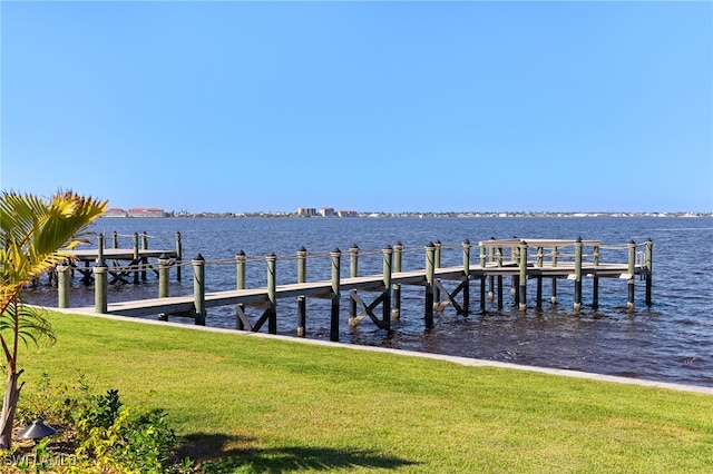 dock area with a water view and a lawn