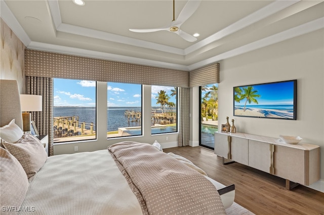 bedroom featuring access to outside, ceiling fan, a tray ceiling, and hardwood / wood-style flooring