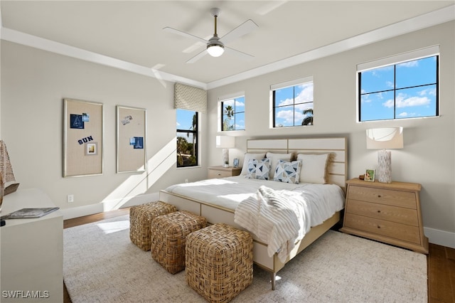 bedroom featuring hardwood / wood-style floors, ceiling fan, and crown molding