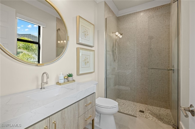 bathroom with vanity, toilet, and a tile shower