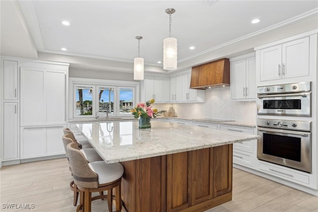 kitchen with custom exhaust hood, a center island, stainless steel double oven, black electric stovetop, and white cabinets