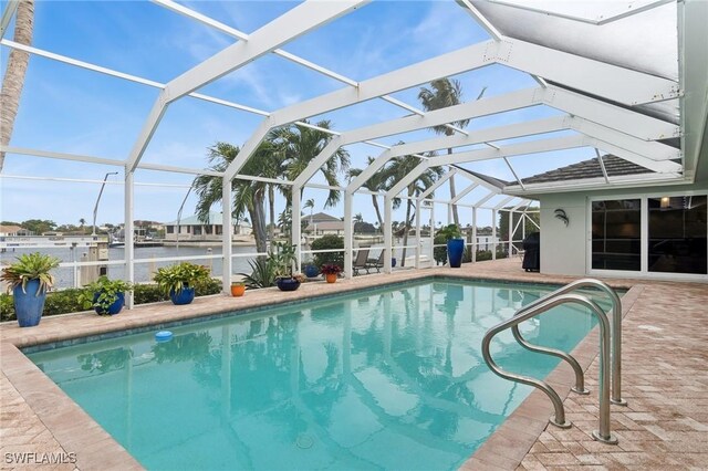 view of swimming pool with a patio and a lanai