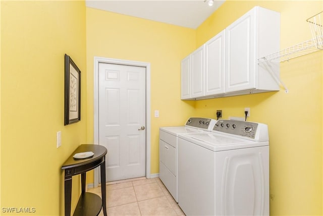 laundry room featuring cabinets, light tile patterned floors, and washing machine and dryer