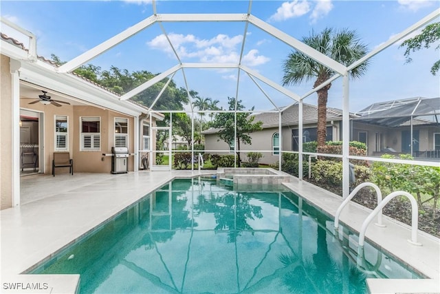 view of swimming pool with ceiling fan, area for grilling, a lanai, and a patio