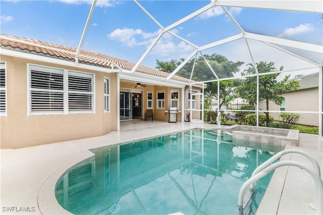 view of pool featuring glass enclosure, ceiling fan, and a patio