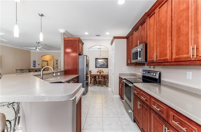 kitchen featuring decorative light fixtures, stainless steel appliances, ceiling fan, and crown molding