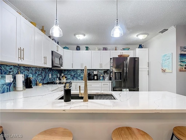 kitchen featuring pendant lighting, fridge with ice dispenser, and a breakfast bar area