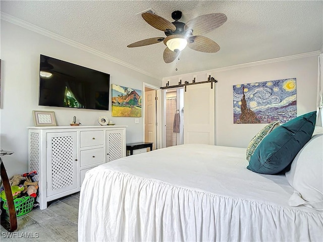 bedroom with ceiling fan, crown molding, light hardwood / wood-style floors, and a textured ceiling