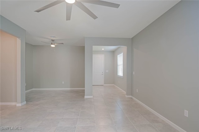 tiled spare room with ceiling fan