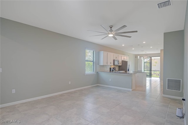 kitchen with white cabinetry, ceiling fan, stainless steel fridge with ice dispenser, backsplash, and kitchen peninsula