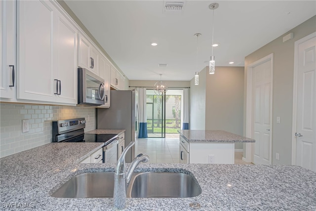 kitchen featuring light stone counters, sink, white cabinetry, and stainless steel appliances