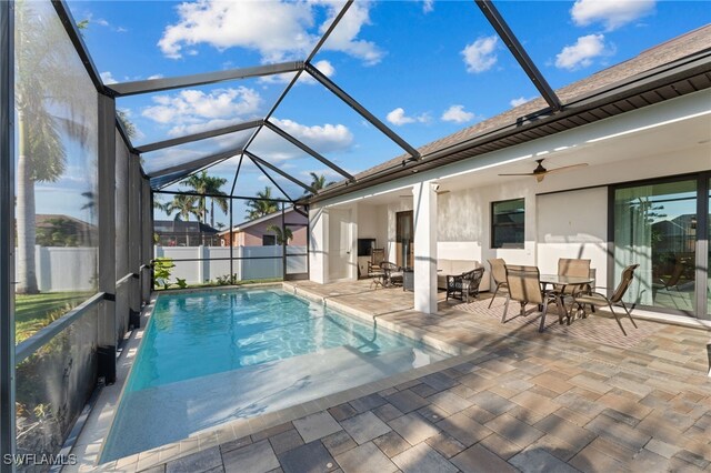 view of pool with a lanai, ceiling fan, and a patio