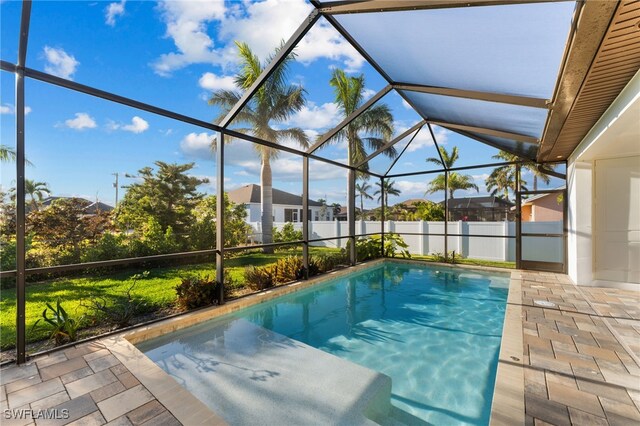 view of swimming pool with glass enclosure and a patio area