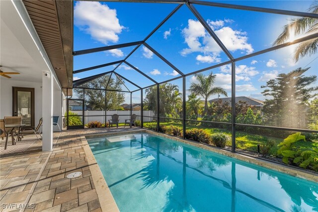 view of swimming pool featuring a patio area, ceiling fan, and a lanai