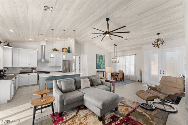 living room with french doors, sink, light tile patterned flooring, and lofted ceiling