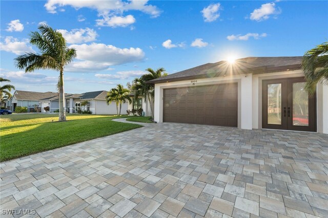 ranch-style home featuring a garage, a front yard, and french doors