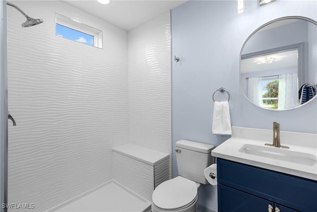 bathroom featuring vanity, toilet, and a tile shower