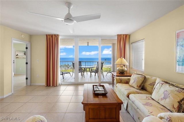 tiled living room featuring floor to ceiling windows, a water view, and ceiling fan