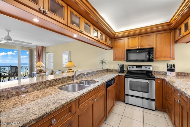 kitchen with light stone countertops, sink, ceiling fan, and black appliances