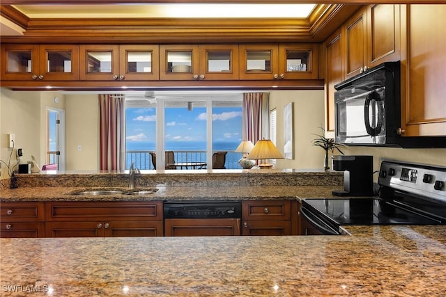 kitchen with sink, black appliances, and stone countertops