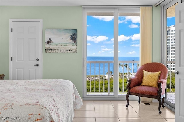 tiled bedroom featuring expansive windows, a water view, and access to exterior