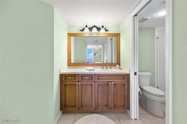 bathroom with tile patterned flooring, vanity, toilet, and walk in shower