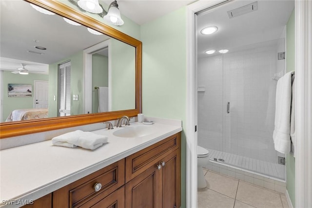 bathroom with tile patterned floors, vanity, ceiling fan, toilet, and a shower with shower door