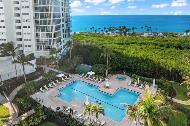 view of pool featuring a water view and a patio