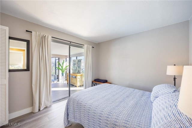 bedroom with light wood-type flooring and access to outside