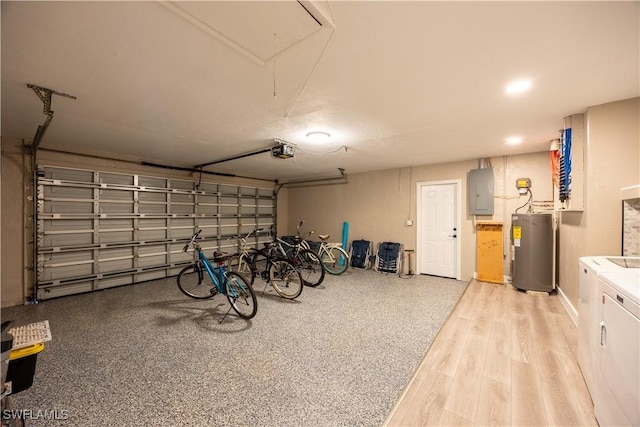 garage featuring electric panel, independent washer and dryer, a garage door opener, and water heater