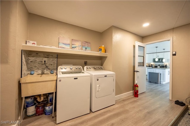 washroom featuring separate washer and dryer, light hardwood / wood-style flooring, and sink