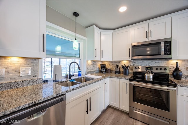 kitchen with white cabinets, appliances with stainless steel finishes, backsplash, and sink