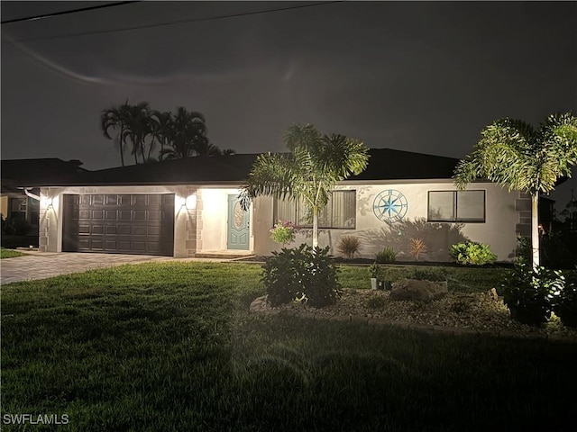 view of front of property with a garage and a yard