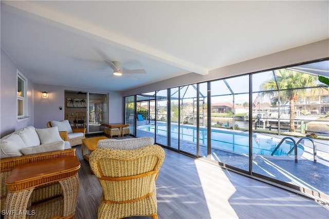 sunroom / solarium with beam ceiling, ceiling fan, a swimming pool, and a water view