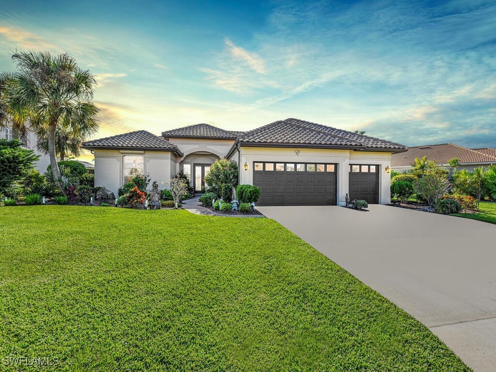 mediterranean / spanish house featuring a yard and a garage