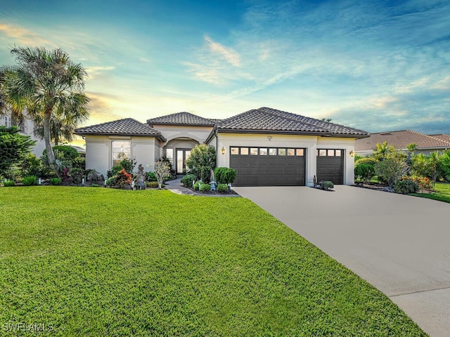 mediterranean / spanish house featuring a yard and a garage