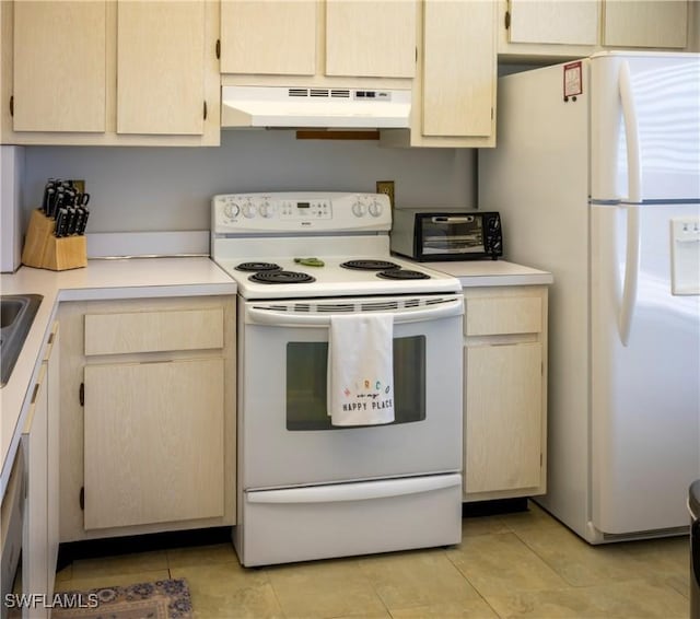 kitchen featuring white appliances, light countertops, under cabinet range hood, and light tile patterned flooring