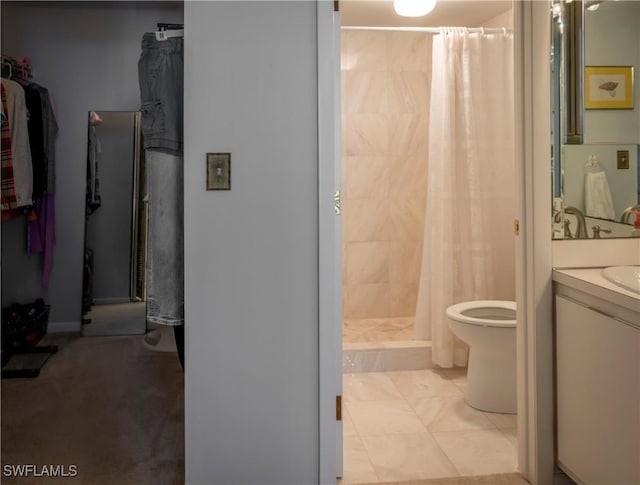 bathroom with tile patterned flooring, toilet, vanity, a spacious closet, and a stall shower