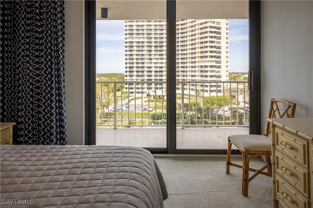 bedroom featuring light colored carpet, multiple windows, and a view of city