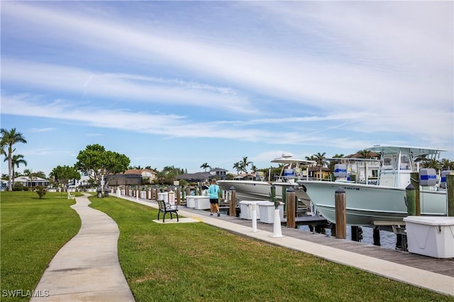 view of dock featuring a water view, boat lift, and a yard