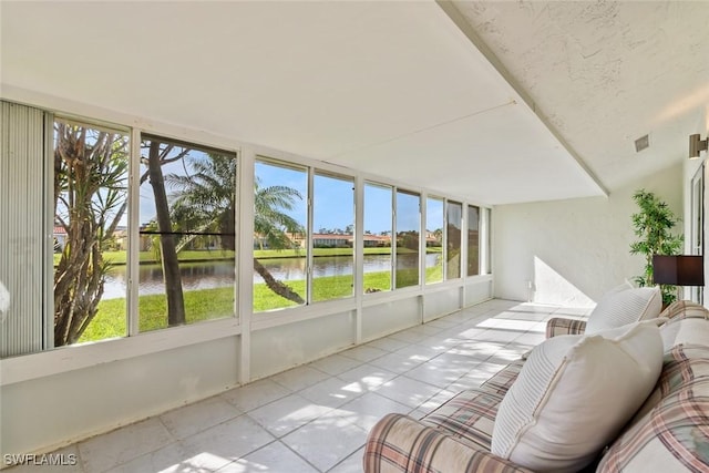 sunroom / solarium with a water view and a healthy amount of sunlight