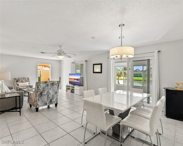 dining room featuring light tile patterned flooring, ceiling fan with notable chandelier, and a textured ceiling