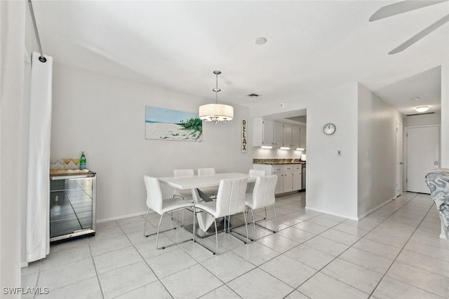 dining area featuring light tile patterned floors, baseboards, and a chandelier