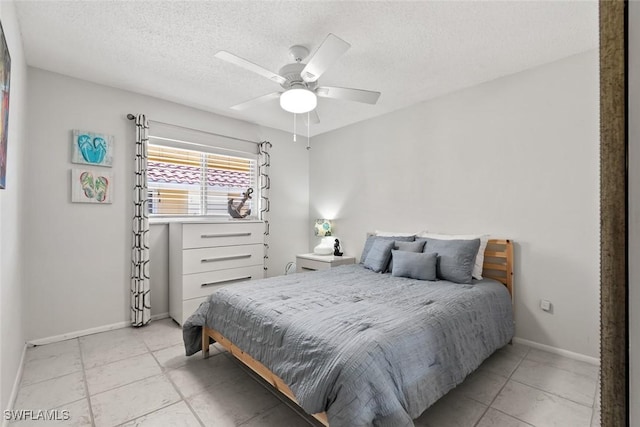 bedroom with a ceiling fan, baseboards, and a textured ceiling