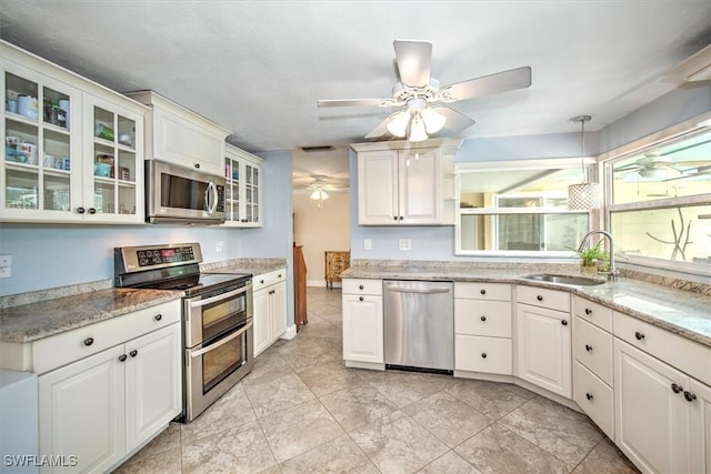 kitchen featuring white cabinetry, sink, hanging light fixtures, and appliances with stainless steel finishes