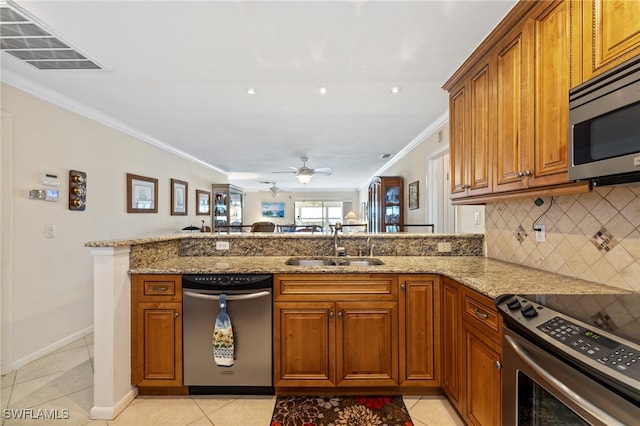 kitchen featuring light tile patterned floors, kitchen peninsula, stainless steel appliances, light stone countertops, and sink