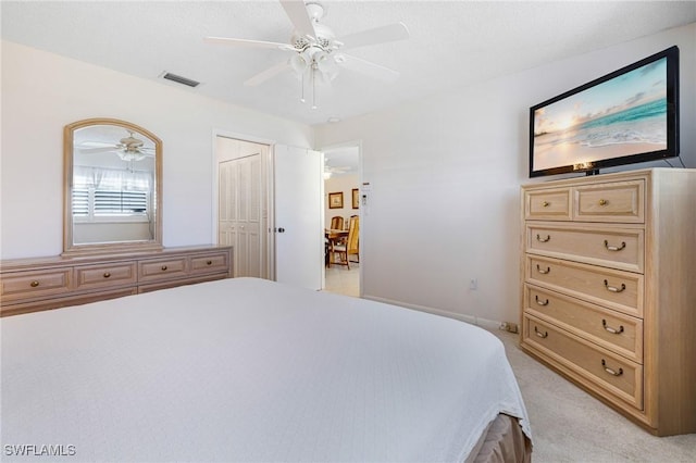 bedroom featuring ceiling fan, light colored carpet, and a closet